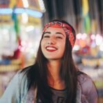 selective focus photography of smiling woman wearing red and black bandana